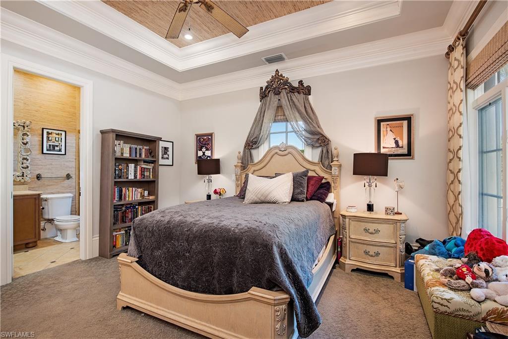 6265 Highcroft Drive Naples, FL 34119 - Photo 15 of 22 a bedroom with a bed and a chandelier