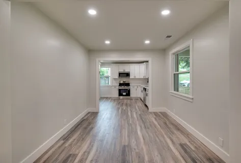 a view of a kitchen with wooden floor electronic appliances and window
