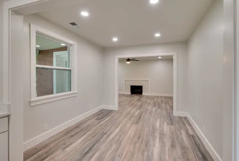 a view of empty room with wooden floor and windows