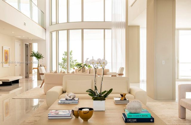 a dining room with furniture a chandelier and kitchen view