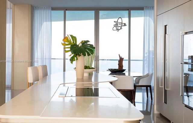 a living room with table and a potted plant