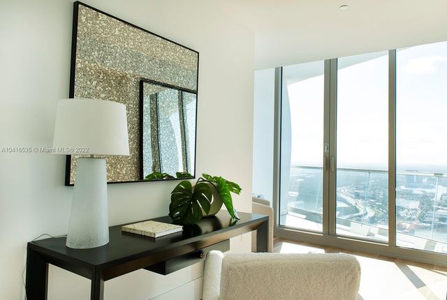 a bedroom with a large bed and a potted plant