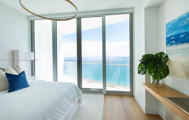 a living room with furniture and floor to ceiling windows