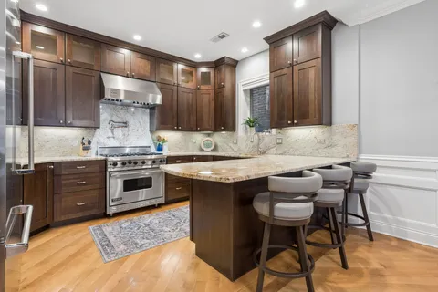 a kitchen with granite countertop a sink stove and refrigerator