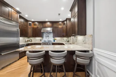 a kitchen with a sink and chairs
