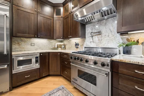 a kitchen with stainless steel appliances granite countertop a stove and a microwave