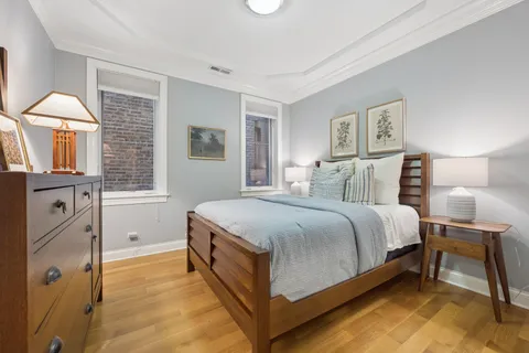 a bedroom with a bed and a lamp on dresser