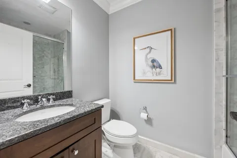 a bathroom with a granite countertop toilet sink and mirror