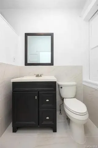 a bathroom with a sink vanity and a toilet
