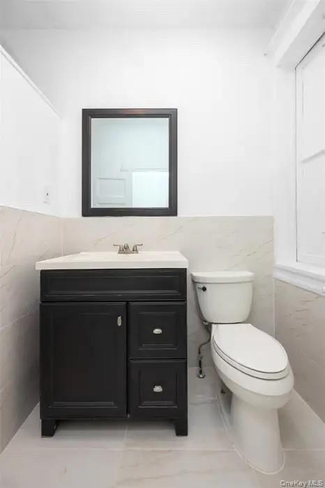 88-08 88th Street Queens, NY 11421 - Photo 11 of 32 a bathroom with a sink vanity and a toilet