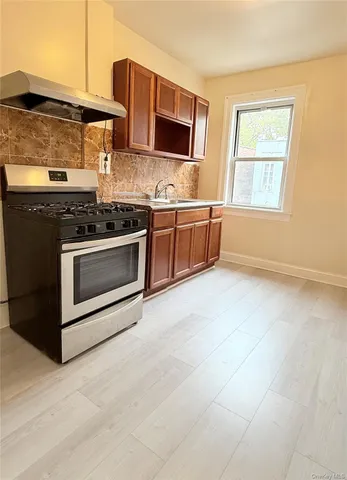 a kitchen with stainless steel appliances a stove a sink and a microwave