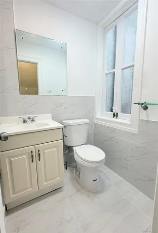 a bathroom with a toilet sink vanity and mirror