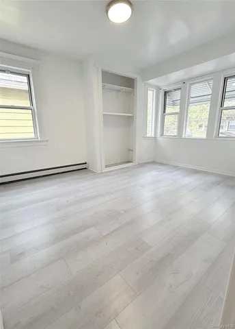 an empty room with windows and closet