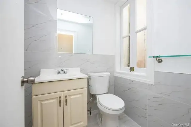 a bathroom with a sink toilet and window