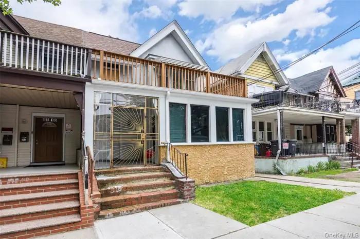 88-08 88th Street Queens, NY 11421 - Photo 3 of 32 a front view of a house with a yard table and chairs