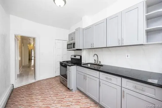 a kitchen with granite countertop a sink stove and cabinets