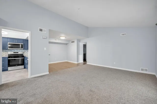 a view of an empty room with a kitchen