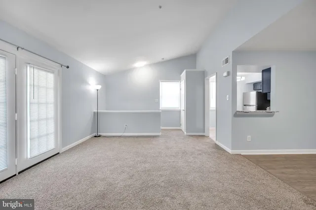 a view of an empty room with a kitchen