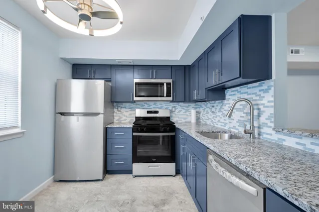 a kitchen with stainless steel appliances granite countertop a refrigerator stove a sink and dishwasher