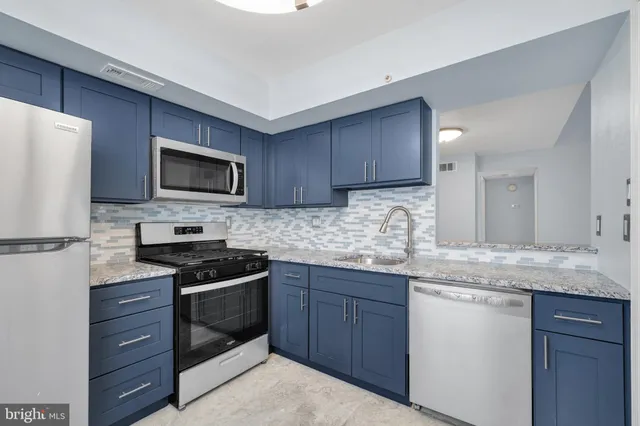 a kitchen with granite countertop a sink and steel appliances