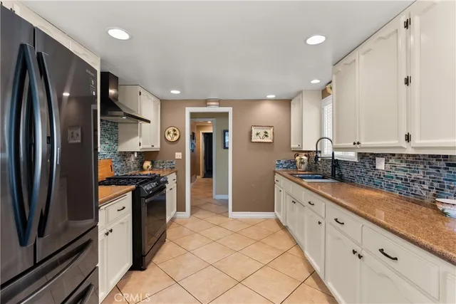 a large kitchen with stainless steel appliances granite countertop a refrigerator and a sink