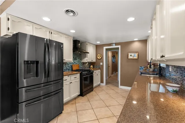 a kitchen with stainless steel appliances granite countertop a refrigerator and a stove top oven