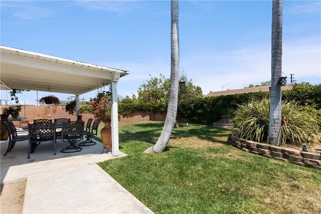 a view of a patio with a table chairs and a floor to ceiling window