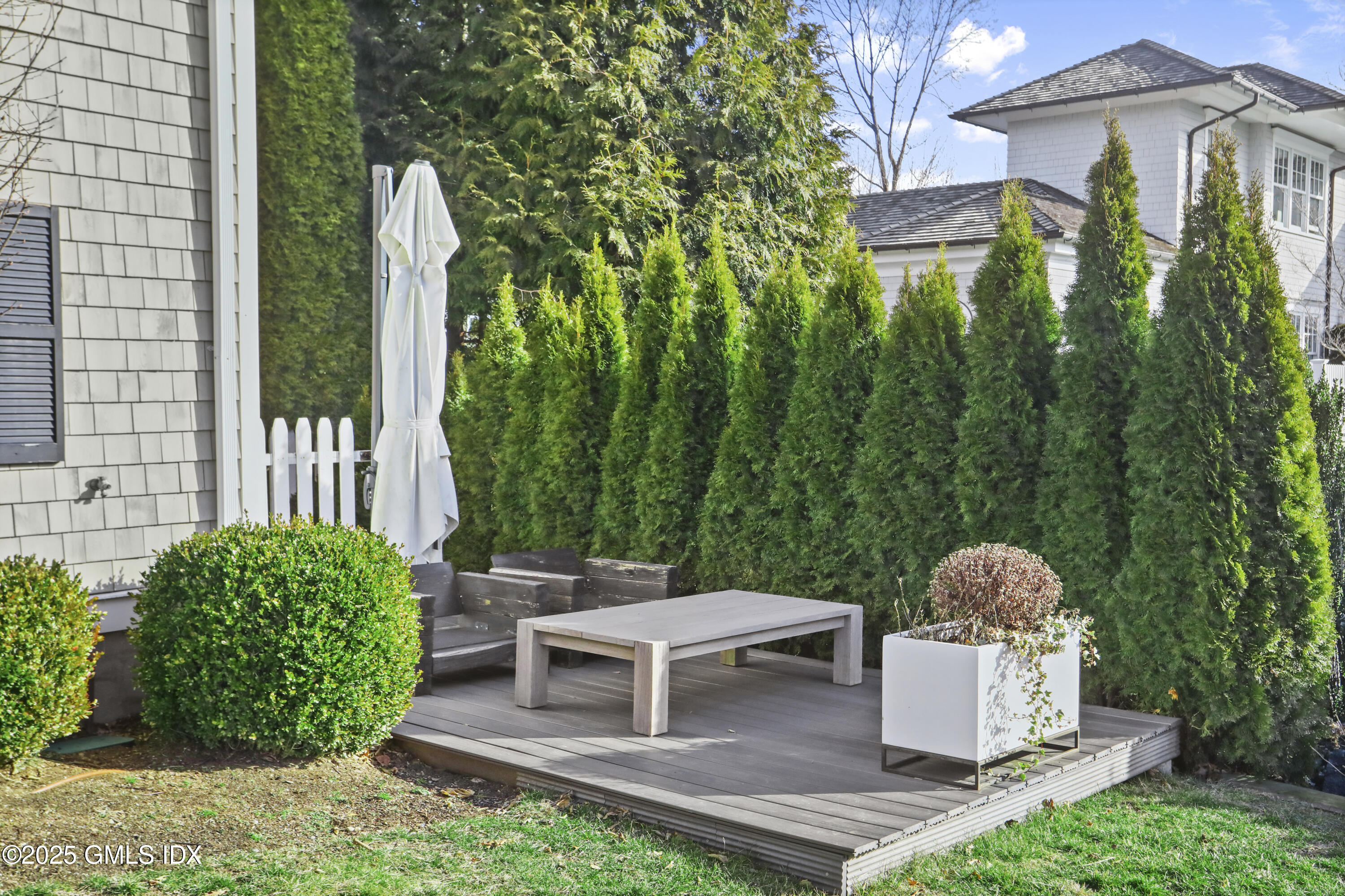 6 Meadowbank Road Old Greenwich, CT 06870 - Photo 23 of 30 a view of a chairs and table in back yard of the house