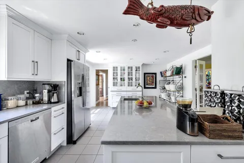 a kitchen with stainless steel appliances granite countertop a sink a stove and a refrigerator