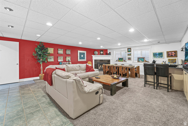 31 Village Square Road Centerville, UT 84014 - Photo 16 of 29 Open-concept living space with recessed lighting, a built-in wet bar, a fireplace with a white mantel, and multiple windows with white shutters