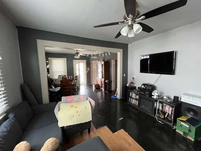 a living room with furniture a flat screen tv and a large window