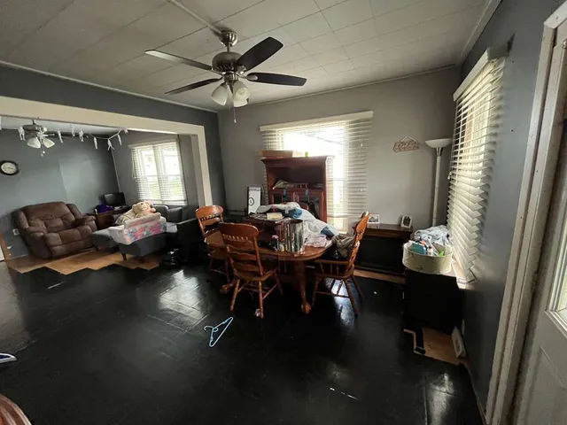 a living room with furniture a chandelier and a dining table
