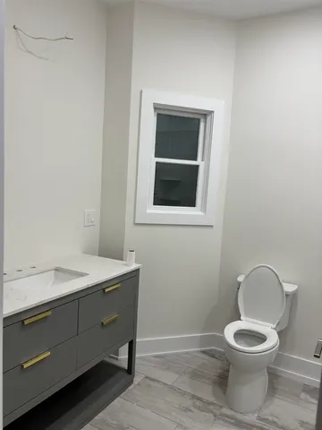 a bathroom with a toilet a sink and mirror