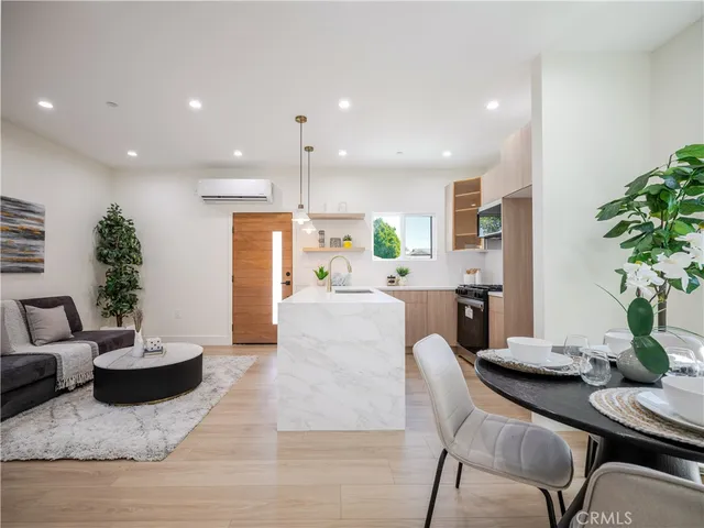 a living room with furniture kitchen and a potted plant