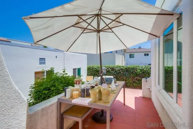 a view of a patio with table and chairs under an umbrella