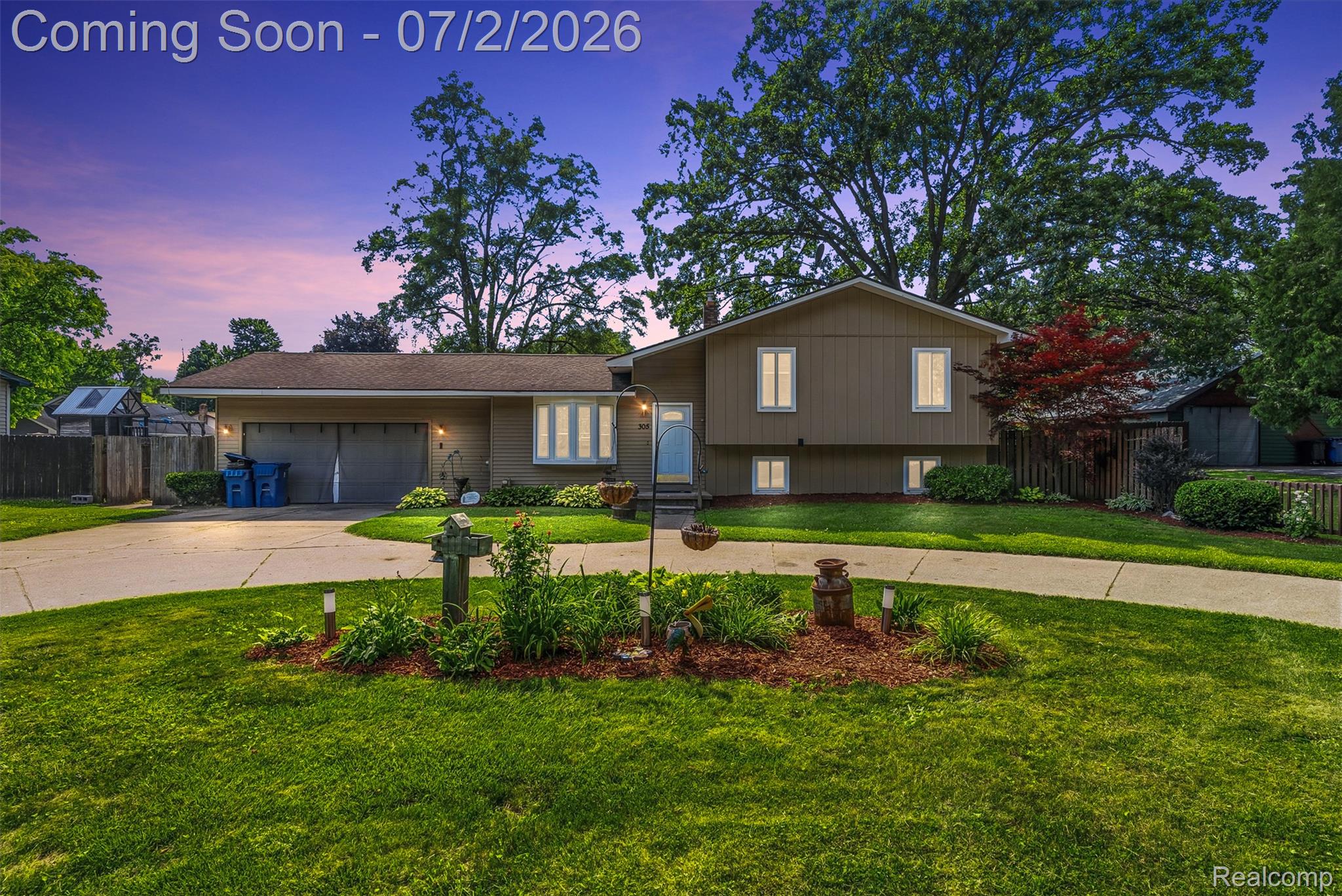 305 East Road Holly, MI 48442 - Photo 1 of 41 Split-level residence featuring a two-car garage, mature trees, and a concrete driveway