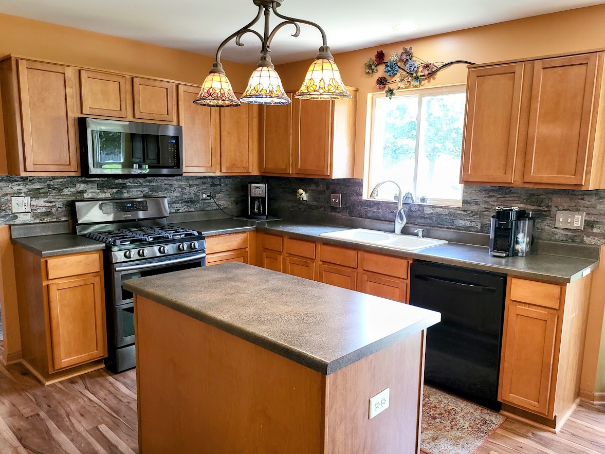 156 Sycamore Drive Bolingbrook, IL 60490 - Photo 6 of 26 a kitchen with stainless steel appliances a sink stove and microwave