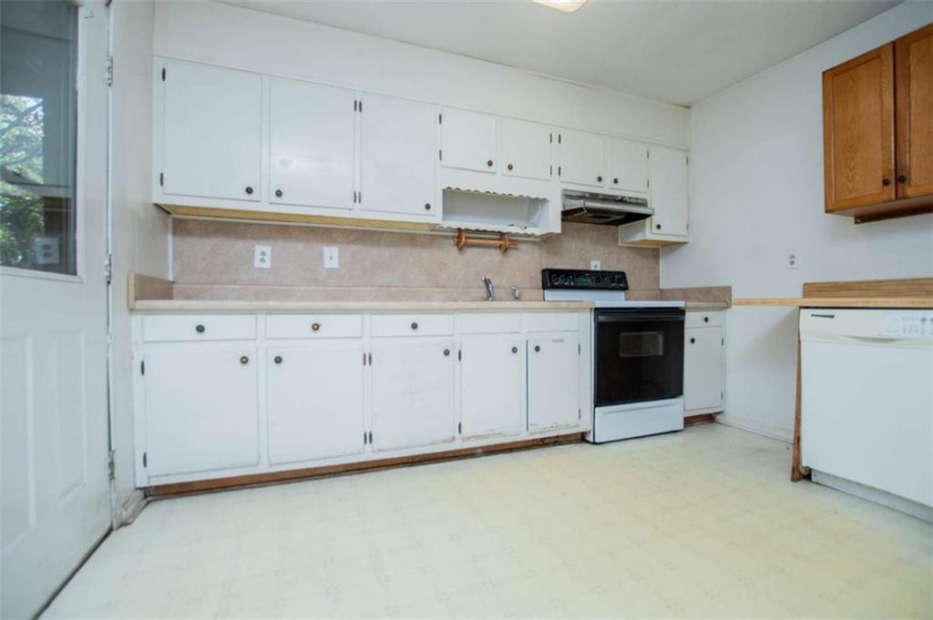 7104 Miller Street Lithia Springs, GA 30122 - Photo 6 of 18 a kitchen with granite countertop white cabinets and white appliances