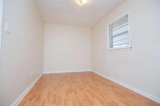 a view of a room that has wooden floor and view of a small space