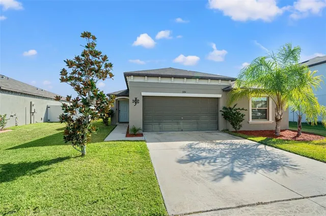 a front view of a house with a yard and garage