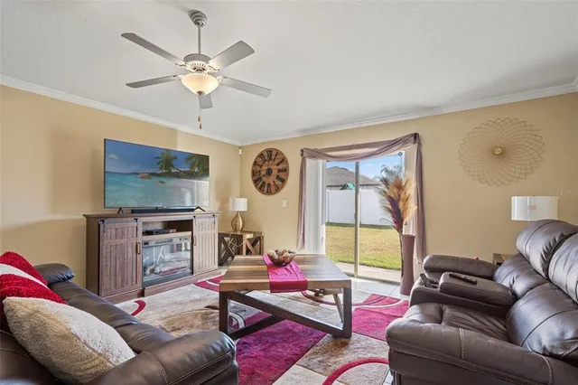 a living room with furniture a flat screen tv and a window