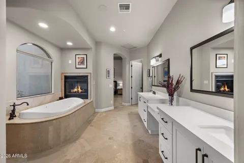 a spacious bathroom with a tub a sink and mirror