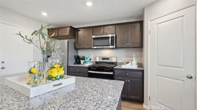 a kitchen with stainless steel appliances kitchen island granite countertop a refrigerator and microwave