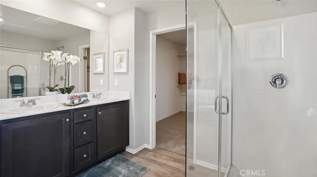 a bathroom with a double vanity sink mirror and shower