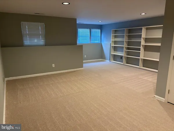 a view of an empty room with closet and a window