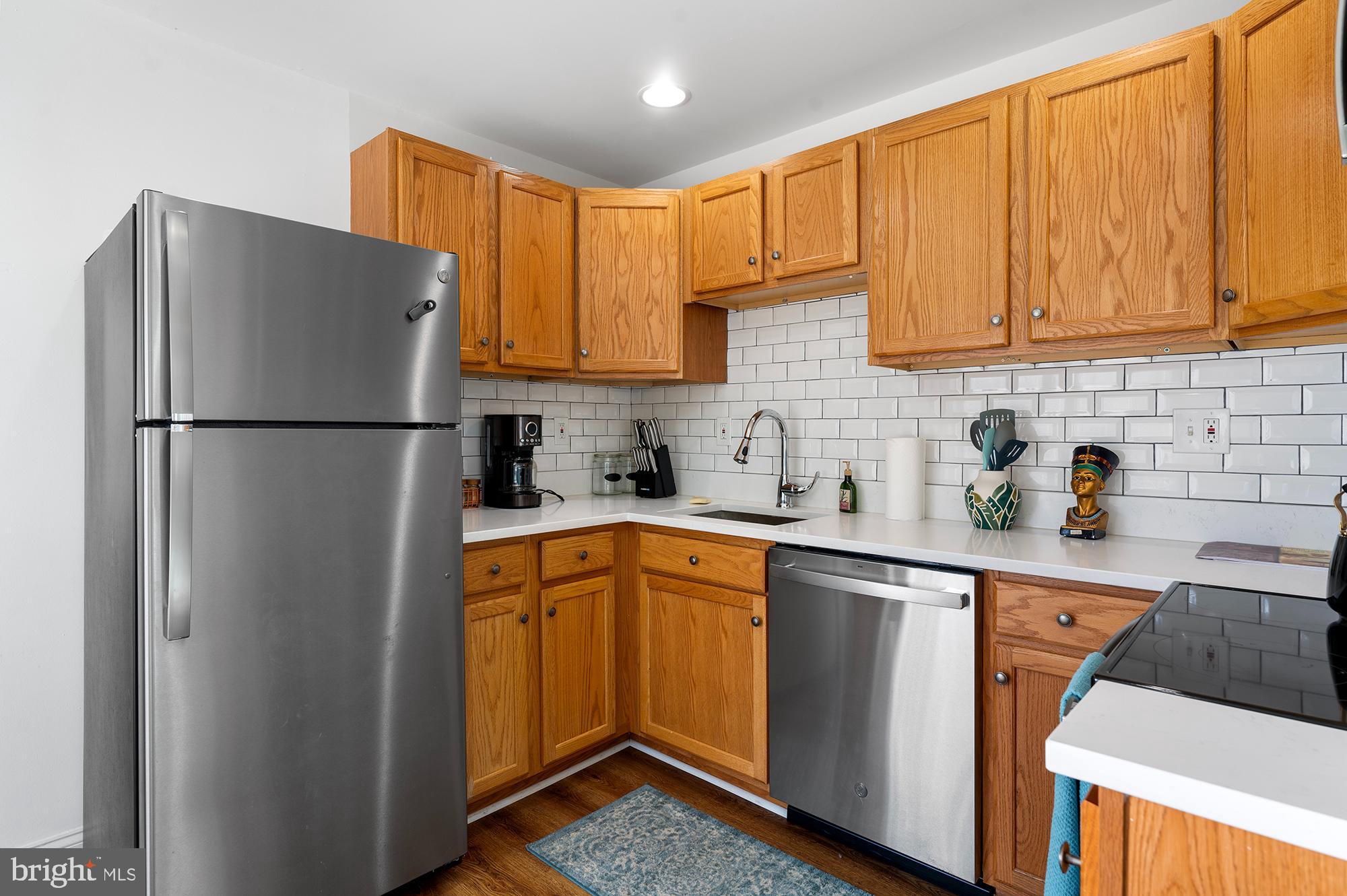 104 Wilson Boulevard Southwest Glen Burnie, MD 21061 - Photo 4 of 23 a kitchen with stainless steel appliances granite countertop a refrigerator a sink dishwasher a stove top oven a refrigerator and cabinets with wooden floor