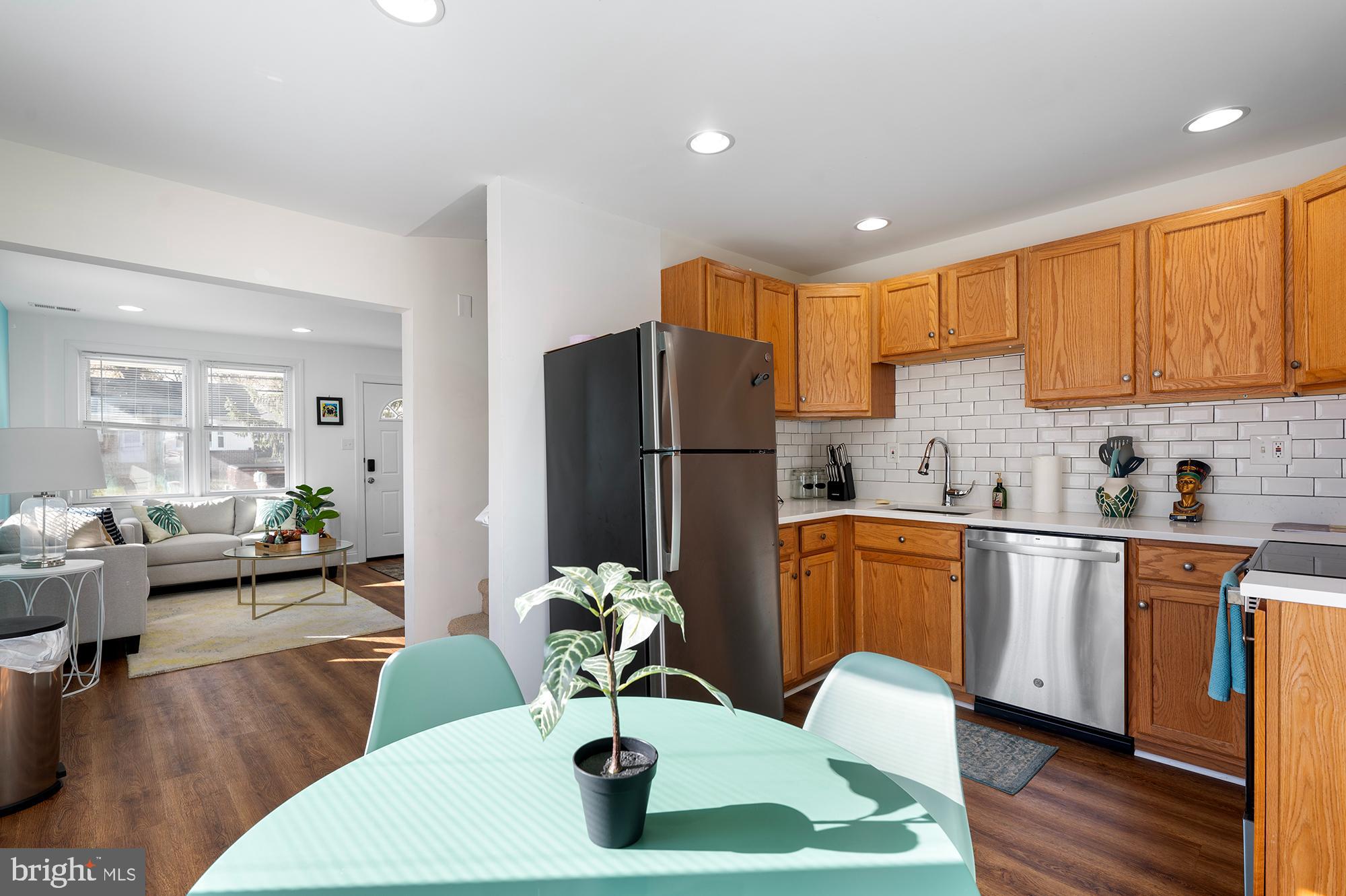 104 Wilson Boulevard Southwest Glen Burnie, MD 21061 - Photo 6 of 23 a kitchen with stainless steel appliances granite countertop a refrigerator a microwave oven a sink dishwasher and white cabinets with wooden floor
