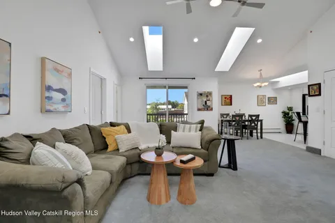 a living room with furniture a ceiling fan and a view of kitchen