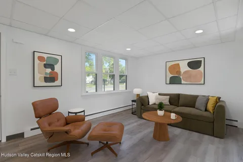 a living room with furniture a rug and a window