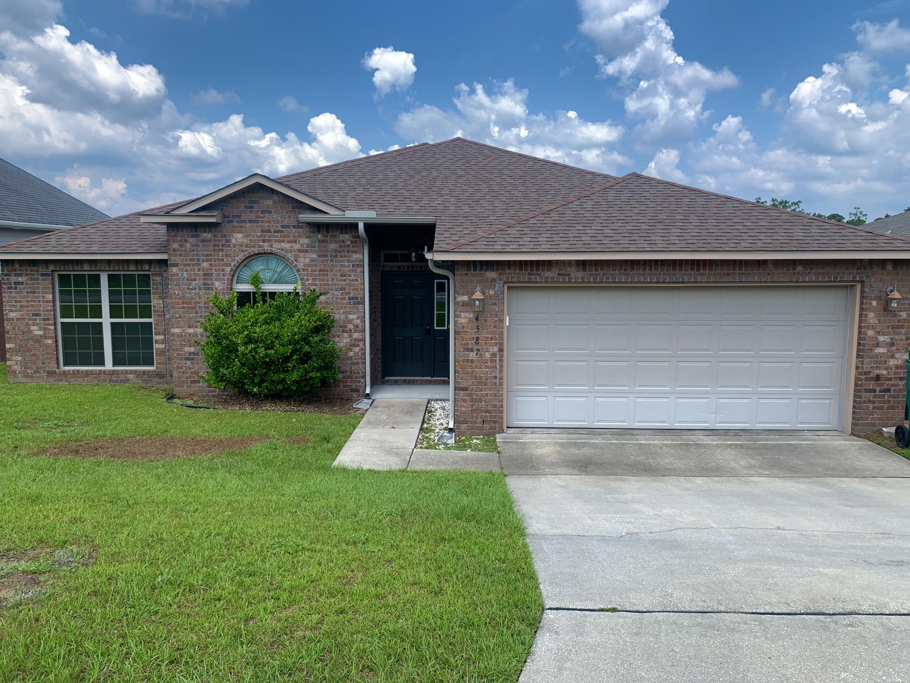 4587 Hermosa Road Crestview, FL 32539 - Photo 1 of 21 a front view of a house with a yard and garage